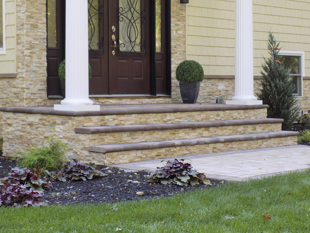 Affordable patio Stacked natural stone steps descend alongside a babbling brook, leading to a lower patio.