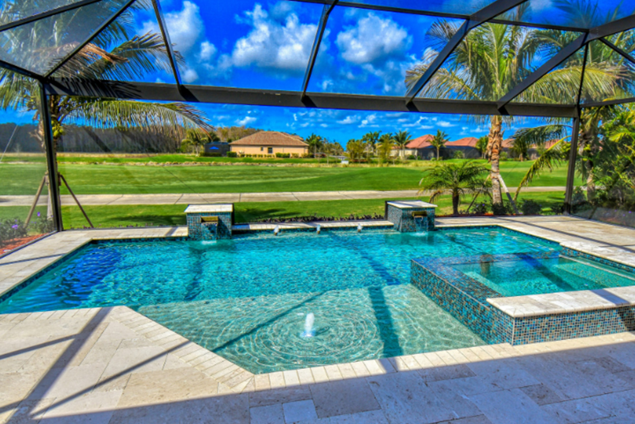 Backyard pool area is completely enclosed by a large black screen structure. The vibrant blue pool features a built-in spa and small fountains, with views overlooking a sprawling green lawn.