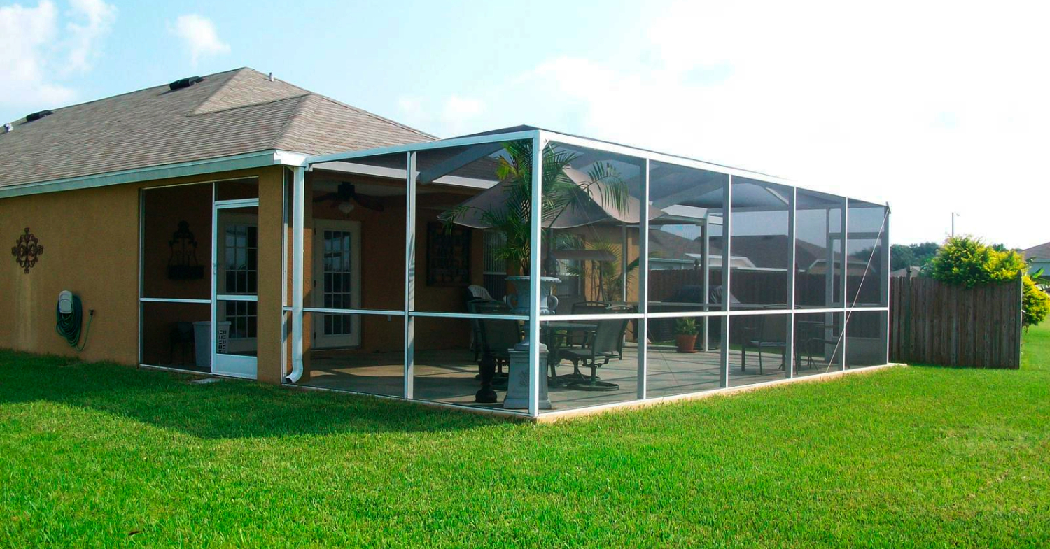 A pristine screened-in porch overlooking a green backyard, perfect for learning tips on how to clean lanai screens.