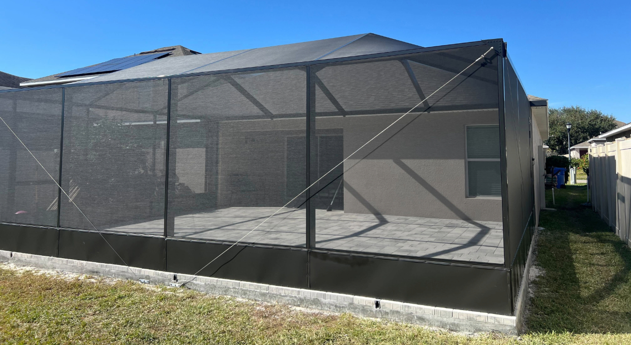 A large backyard structure with a solid bottom panel, demonstrating custom options that affect the lanai screen enclosure cost.