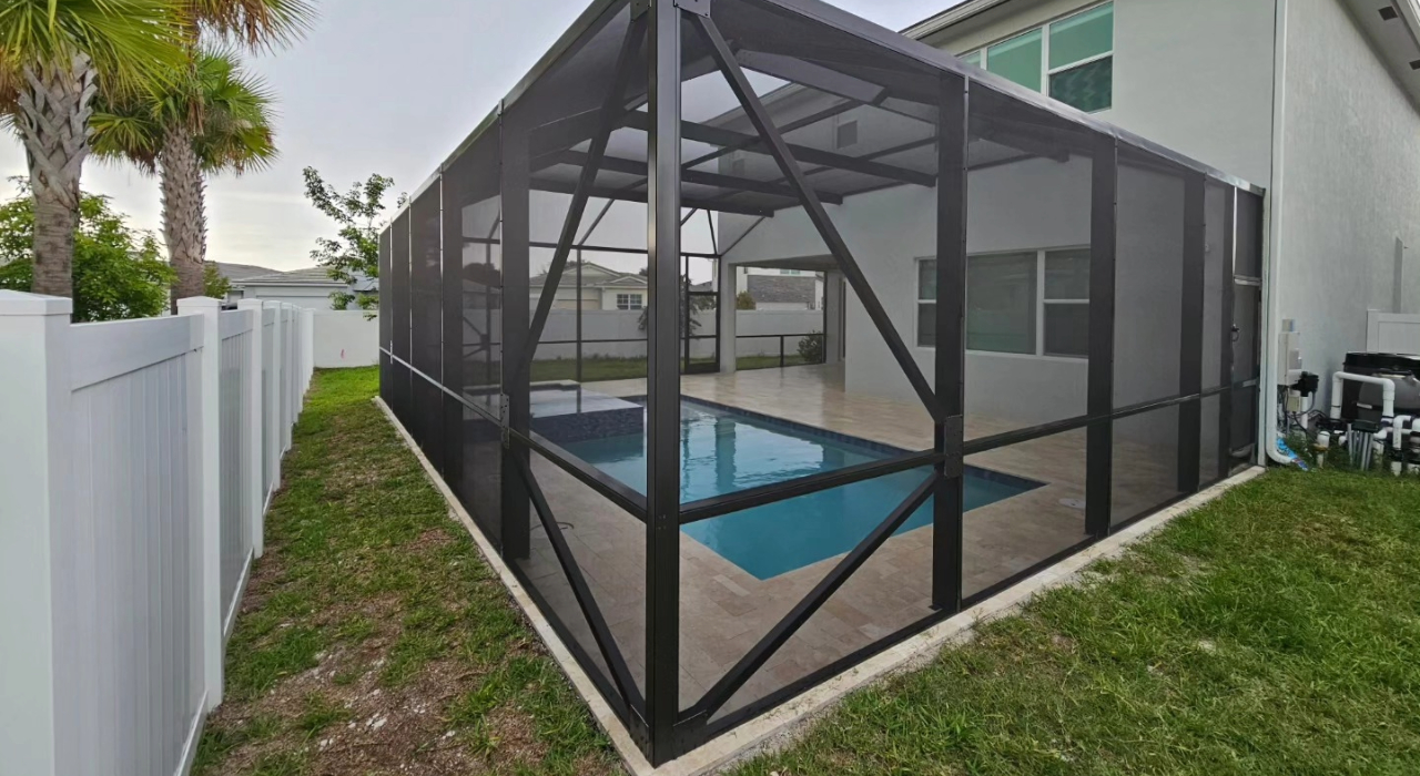 An exterior view of a dark metal frame protecting a backyard swimming pool, illustrating various pool enclosure screen types.