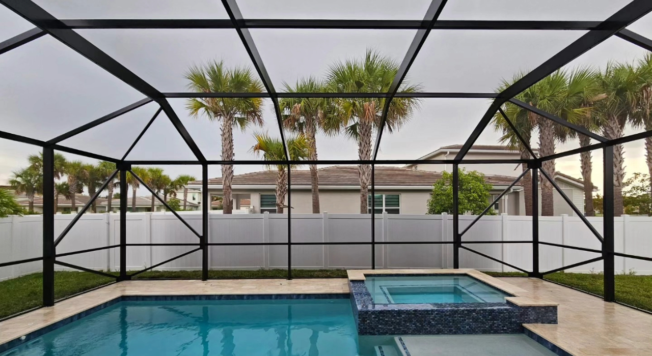 An interior view of a custom pool and spa protected from debris by durable pool enclosure screen types.