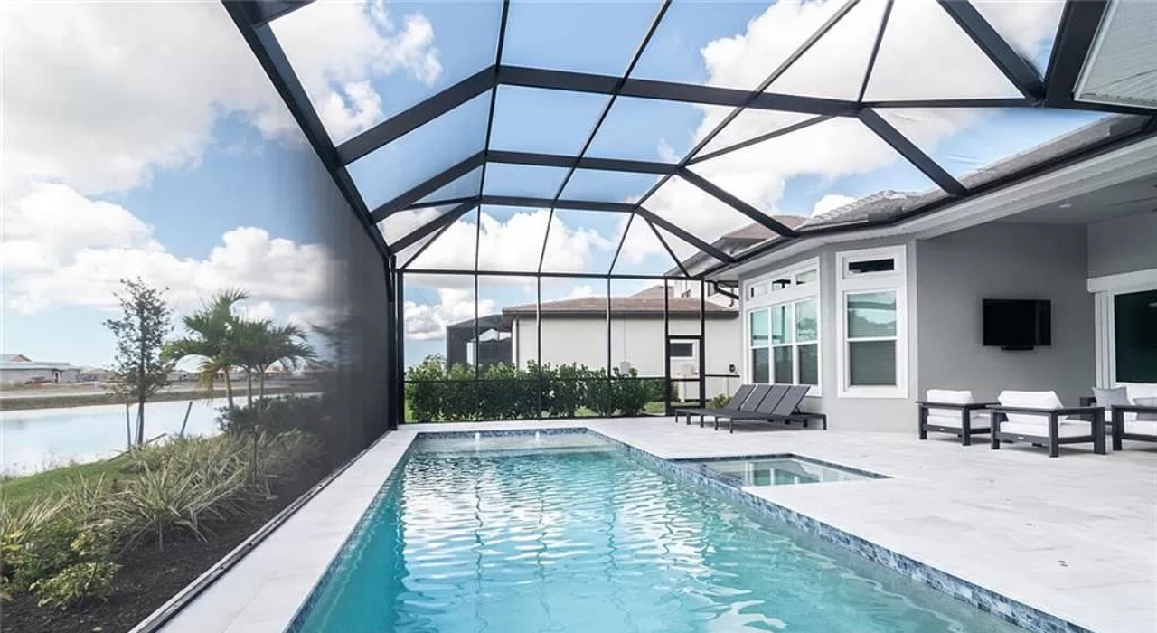 A modern swimming pool featuring a dark mesh wall on one side, showcasing practical privacy screen options for pool enclosure.